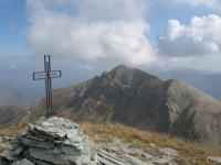 La croce di vetta della Punta Tempesta, e sullo sfondo il Monte Tibert.